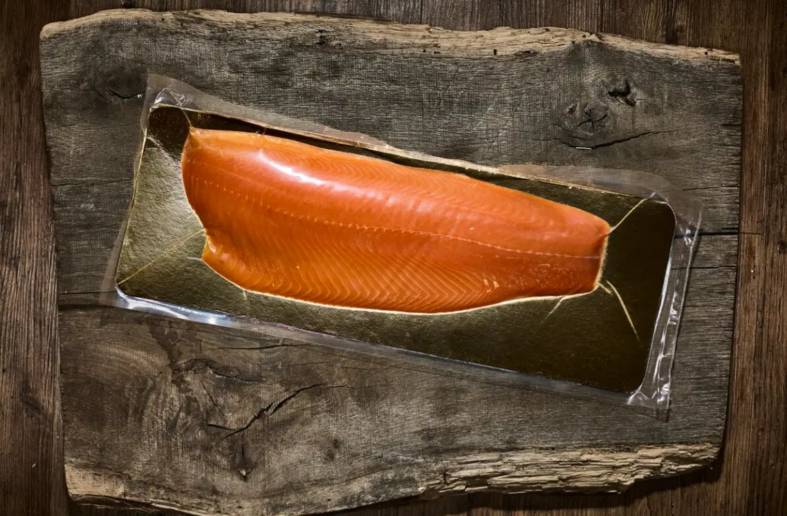 Eingescheißtes Lachsfilet auf einer braunen Holzplatte 
